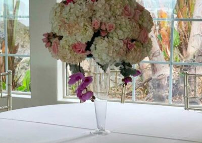 Modern floral arrangement with pink and white flowers in a clear vase on a table; ideal for weddings, corporate or social events in Orange County.