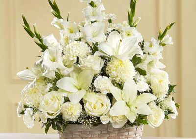 Elegant white floral arrangement with lilies and roses in a basket; perfect for weddings, corporate events, and social gatherings in Orange County.