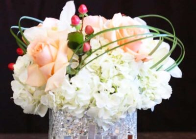 A modern floral arrangement with roses and hydrangeas in a glittery vase, perfect for weddings, corporate events, and social gatherings.