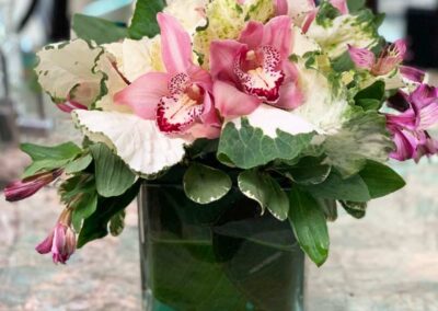 Modern floral arrangement in a glass vase with pink and white flowers. Suitable for weddings, corporate events, and social gatherings.