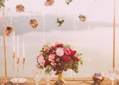 Elegant table setting with colorful floral arrangements, modern design, at a wedding or event in Orange County; candles, and glassware.