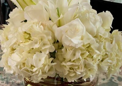 White floral arrangement featuring roses and hydrangeas in a clear glass vase, ideal for weddings, corporate events, and social gatherings in Orange County.