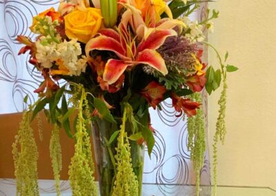 Modern floral arrangement with lilies, roses, and greenery in a vase for wedding or corporate events in Orange County.