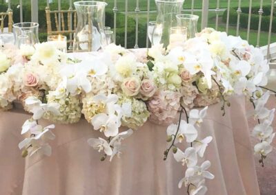 Elegant floral arrangements for a wedding; outdoor event setup with ivory and blush flowers in Orange County.