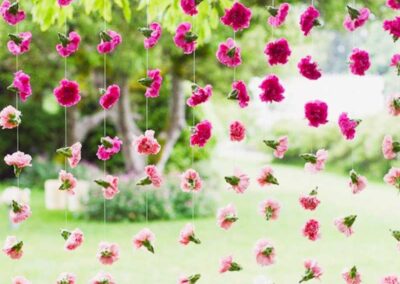 Hanging pink and red flowers in garden setting, ideal for weddings and events. Modern floral design by florist Orange County.
