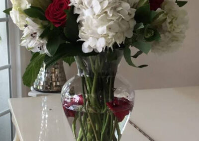 1 dozen long stems red roses with 3 hydrangeas in a tall glass vase. Rose petal fallen in the water. Truly a Love piece.