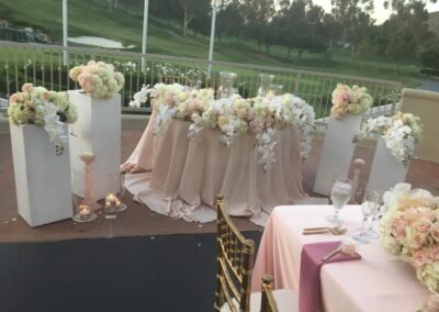 Elegant floral arrangements for a wedding; outdoor event setup with ivory and blush flowers in Orange County.