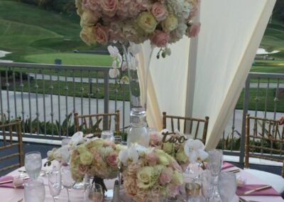 A vibrant floral arrangement featuring pink and white flowers in a tall base vase designed for weddings and wedding anniversaries.